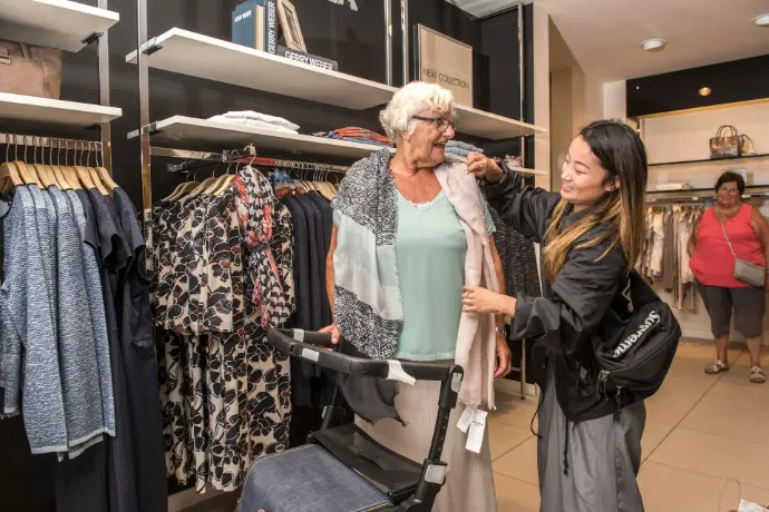 two women are shopping in a clothing store